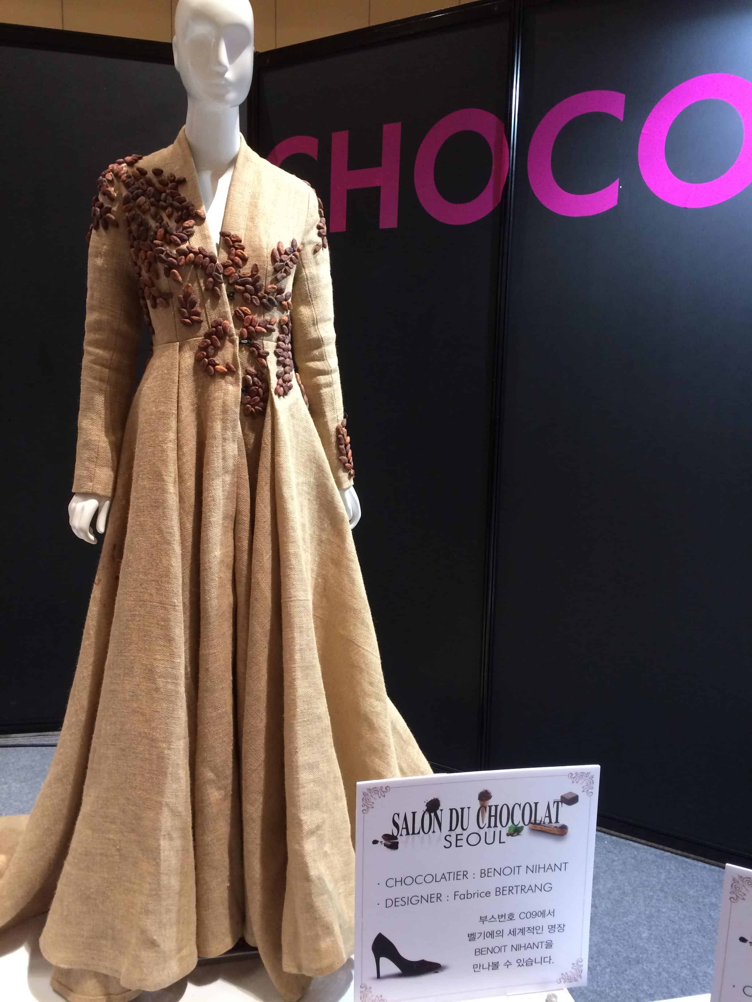 image of a mannequine in an empire-waist tan dress with cocoa beans affixed to the front.