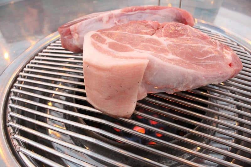 Pork cutlet being grilled.
