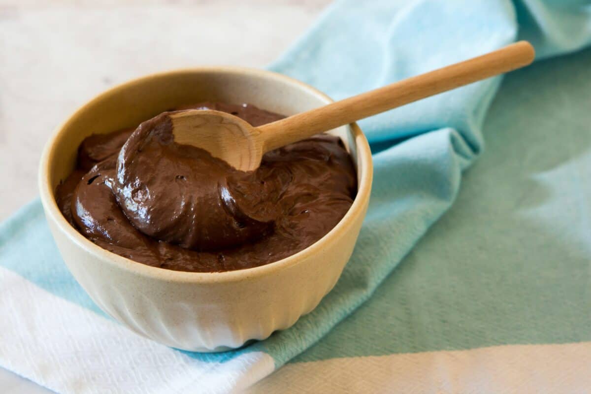 thick and creamy chocolate dipping sauce in ceramic stone ware with spoon