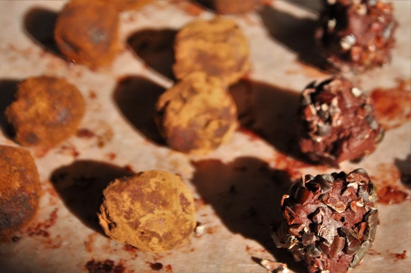 Homemade chocolate truffles coated in cacao nibs on display.