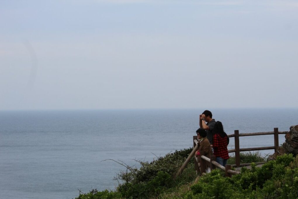 People overlooking the ocean from Seongsan Ilchulbong. 