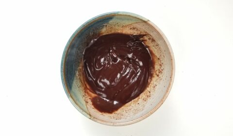 melted chocolate in a small bowl on a white background.