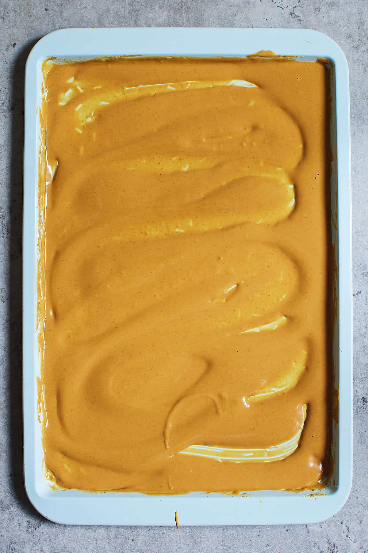 Melted blond chocolate in a baking tray.
