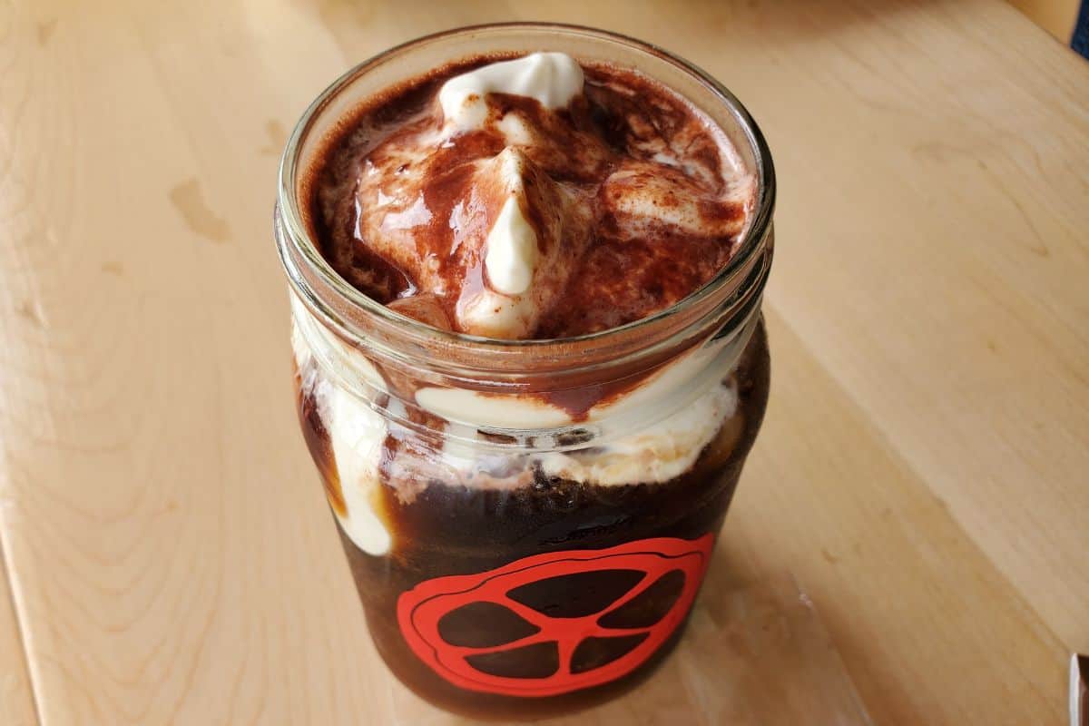 cold brew coffee topped with whipped cream and melted chocolate.