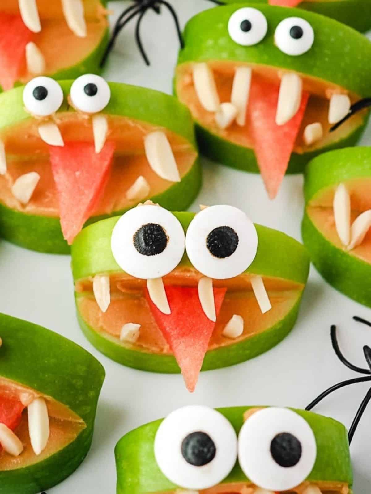 Apple Monsters - Fun and spooky Halloween dessert idea with apple slices, peanut butter, and candy eyes.