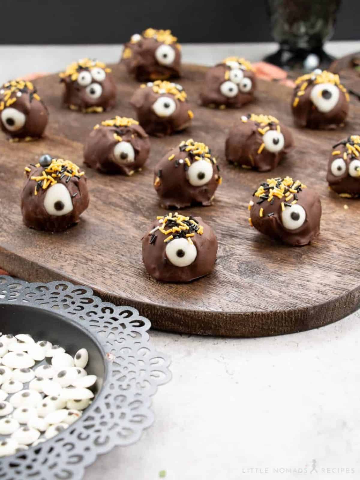 Spooky Monster Eye Pumpkin Cheesecake Bites decorated with candy eyes, ideal for a Halloween dessert.