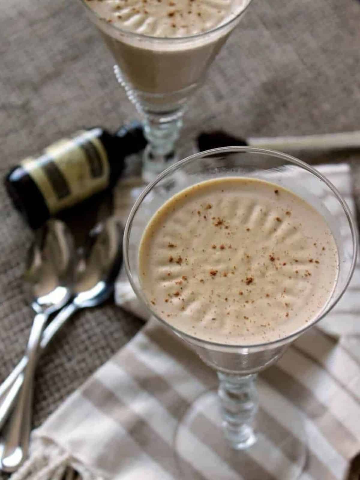 Pumpkin Panna Cotta served in a glass, decorated for Halloween with a spooky theme.