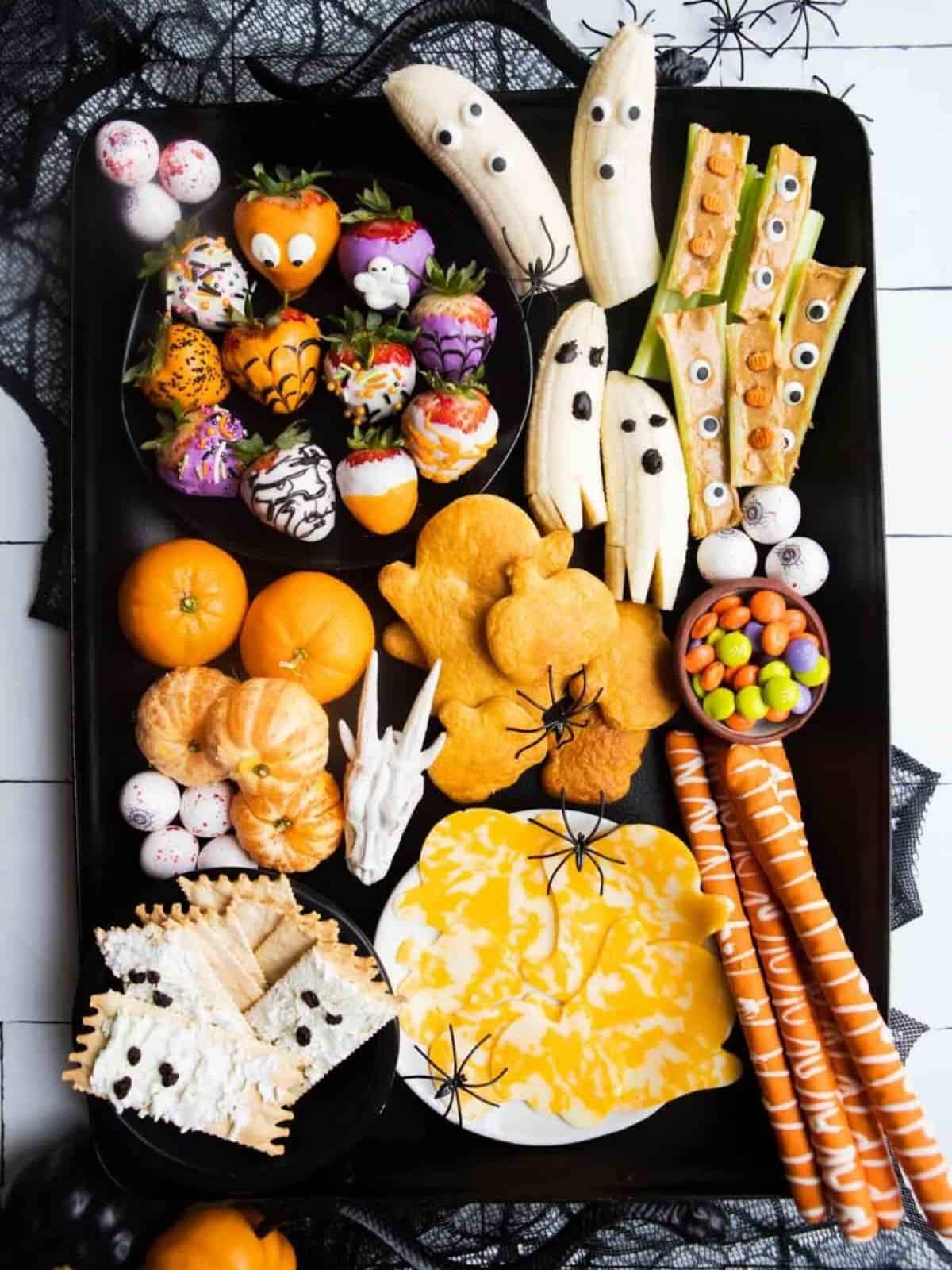 Various Kid-friendly Halloween snacks on a tray.