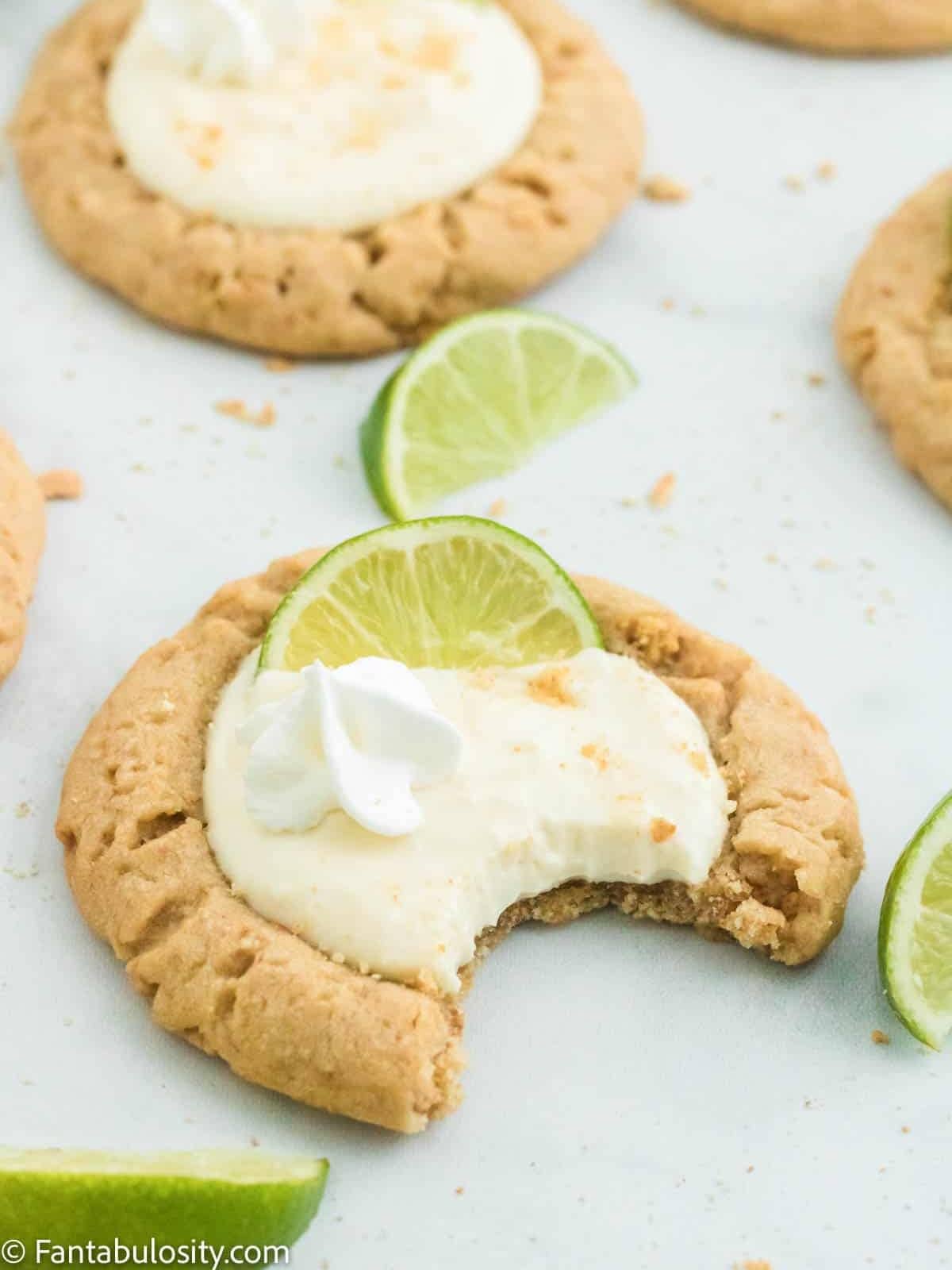 Key Lime Pie Cookies, a Crumbl Copycat recipe, topped with creamy lime frosting and sliced lime.