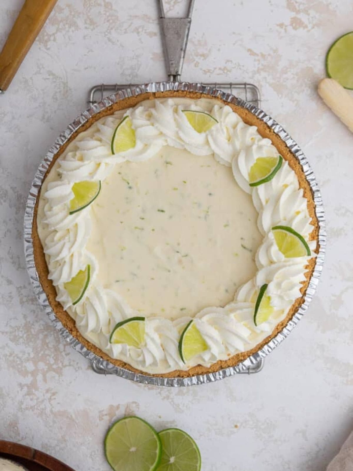 Key Lime Pie topped with cream frosting and lime slices.