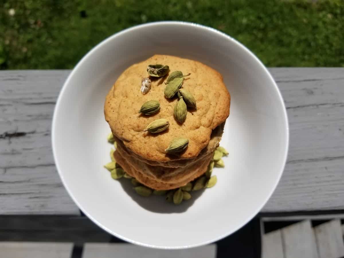 cookies in a stack with cardamom pods on top.