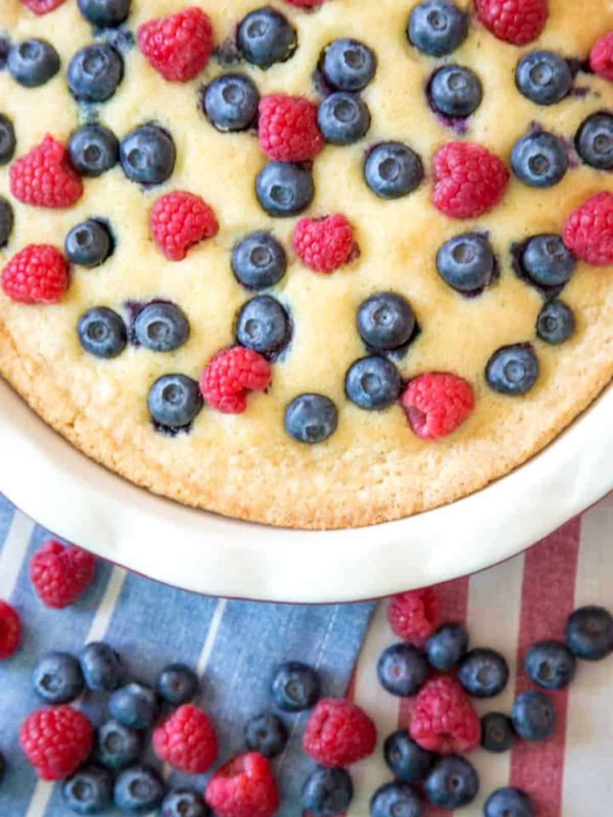 delicious gluten-free berry buttermilk cake topped with fresh berries.