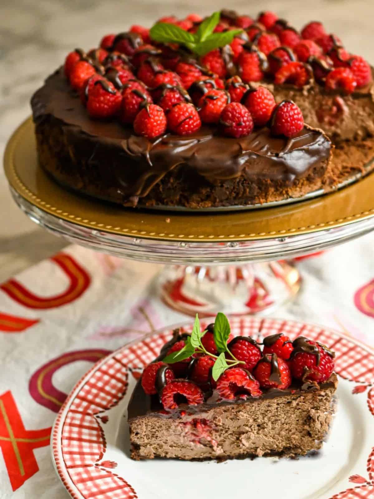 Luscious Chocolate Cheesecake studded with fresh Raspberries, a layer of chocolate ganache, and finally garnished with more fresh raspberries