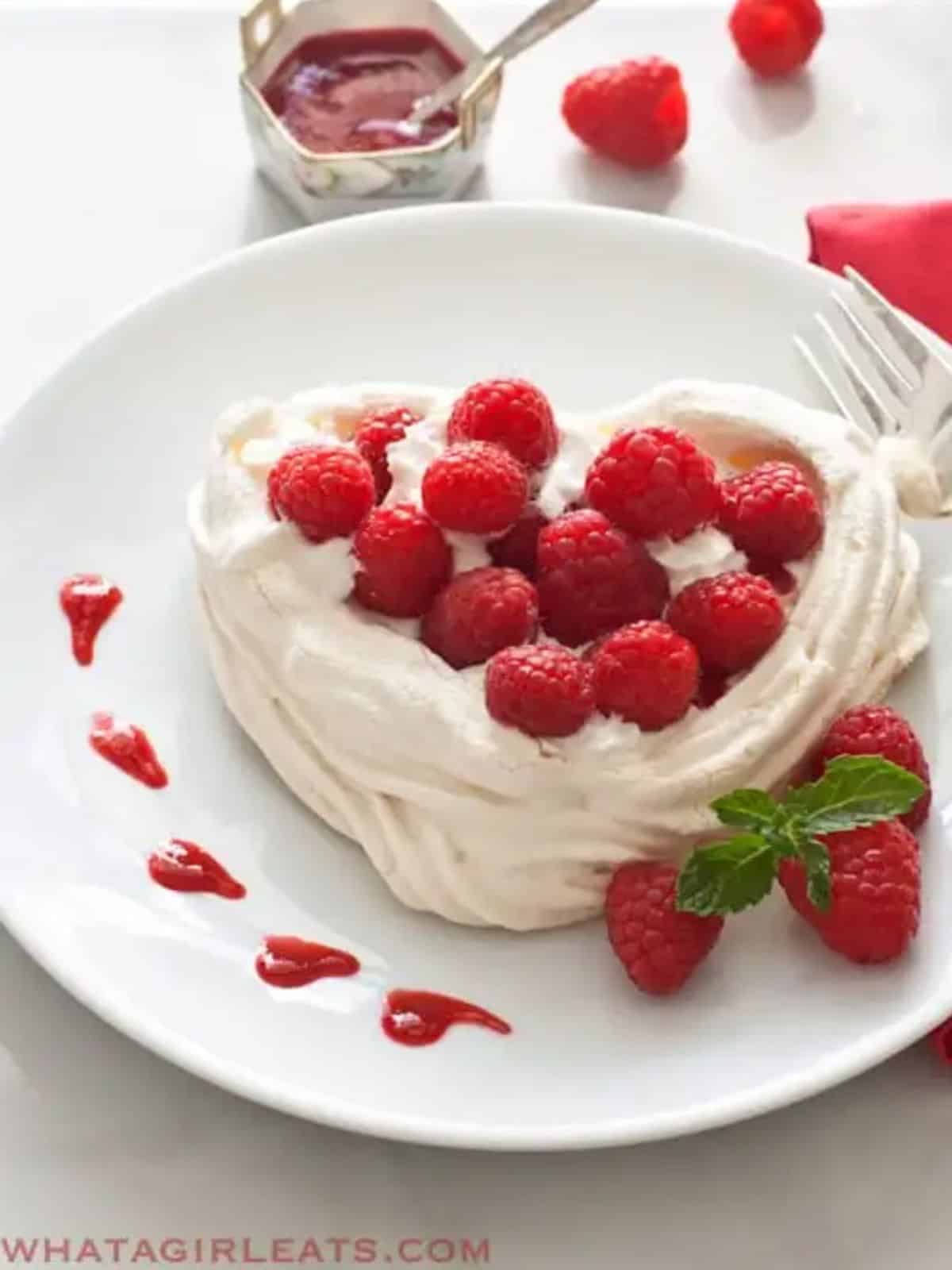 Beauitful white Meringue heart topped with fresh Raspberries