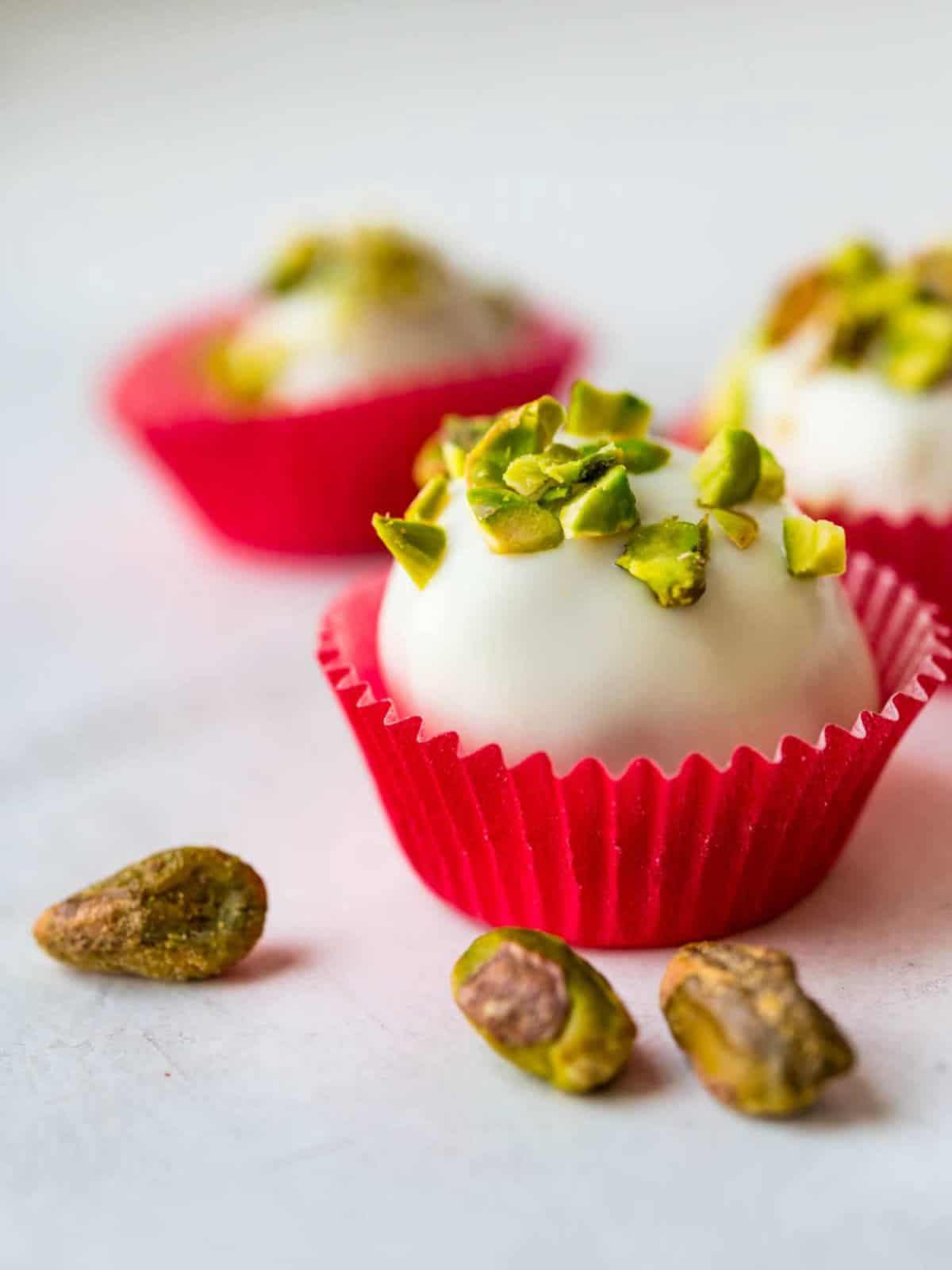 Rum-spiced Cream Cheese Cake coated in White Chocolate topped with Crushed Pistachios
