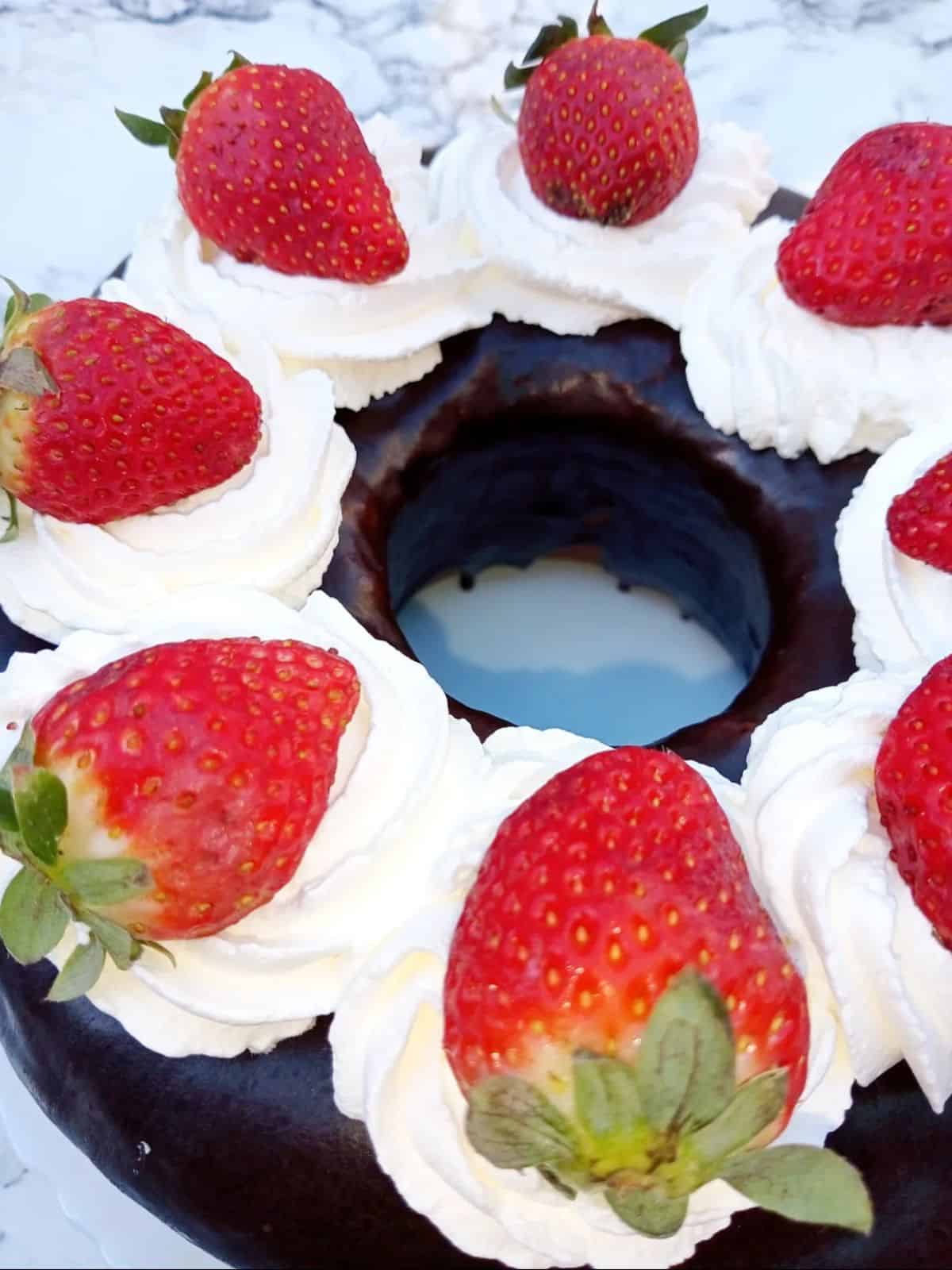 Moist and fluffy Yogurt Cake covered in Chocolate Ganache topped with Fresh Cream and Dtrawberries