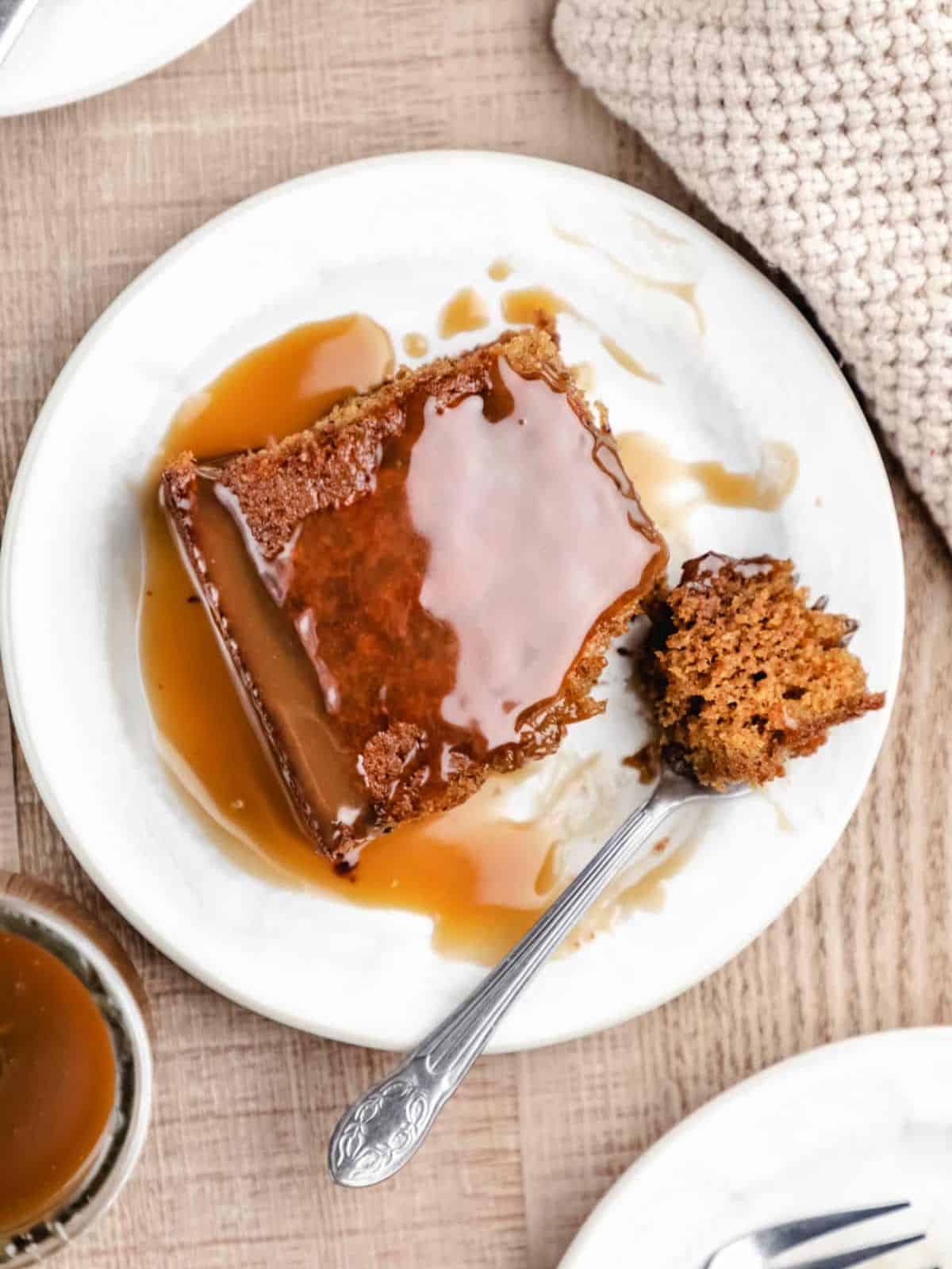a delicious sticky toffee pudding cake, showcasing moist layers filled with dates and drizzled with caramel sauce.