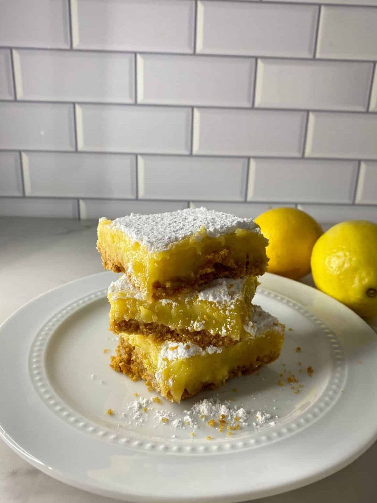 delicious lemon bars with a golden graham cracker crust, showcasing a perfect balance of tangy lemon filling and buttery, crumbly base.
