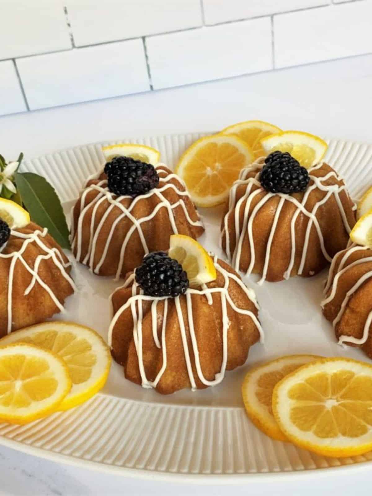 freshly baked lemon olive oil cakes, topped with fresh blackberry and a slice of lemon.