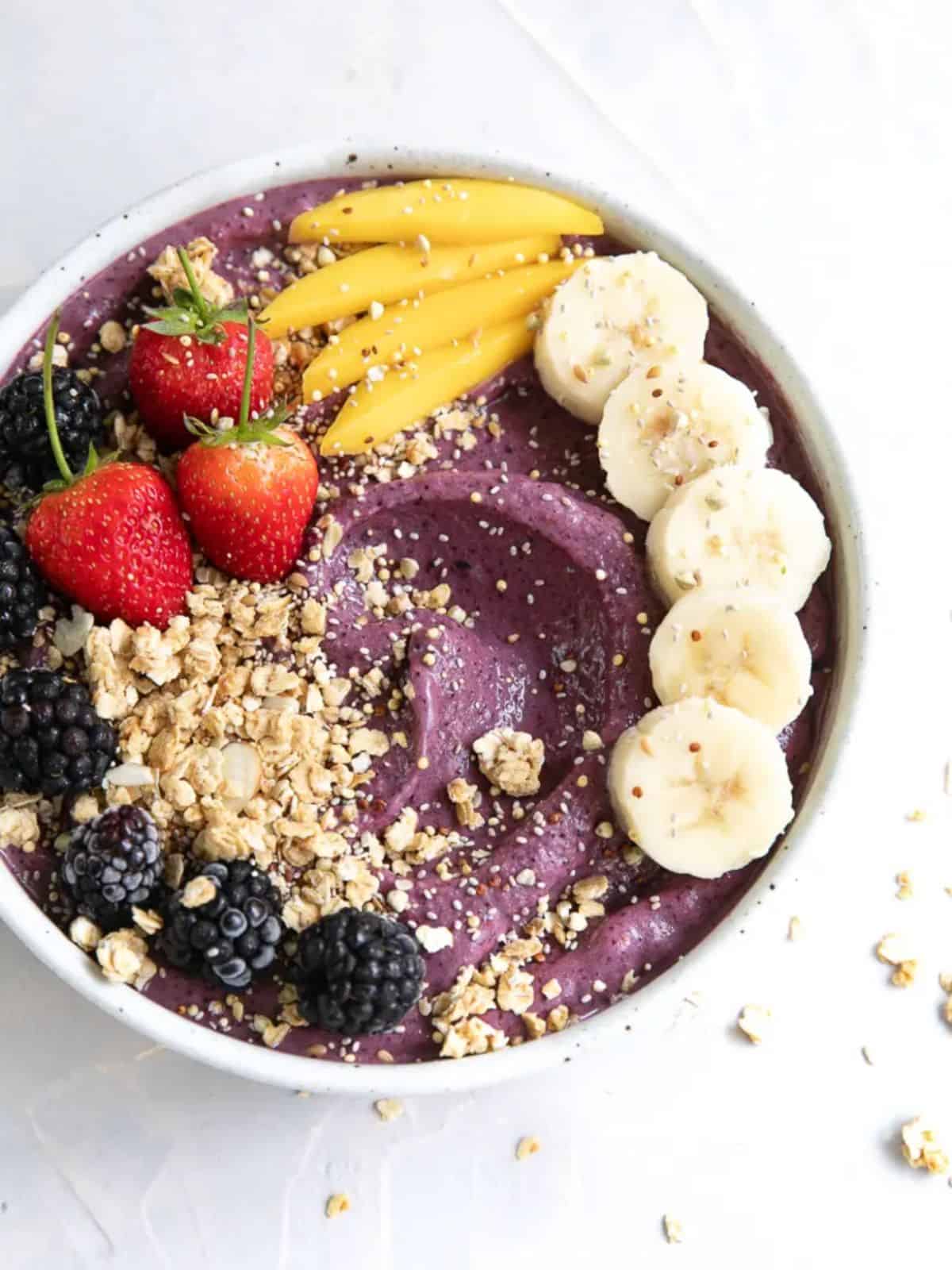 colorful acai bowl topped with fresh variety of fruits.