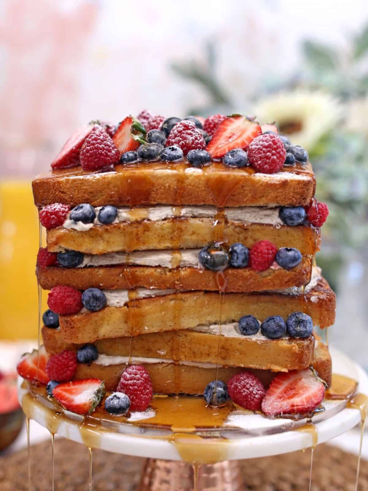 delicious French toast cake, layered with fresh and frozen berries and cream, and drizled with syrup.