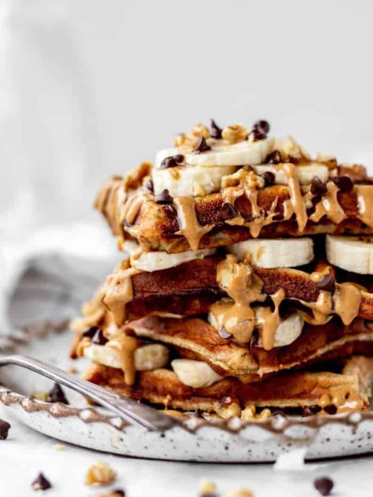 delicious stack of Kodiak protein waffles topped with banana slices and chocolate chips.