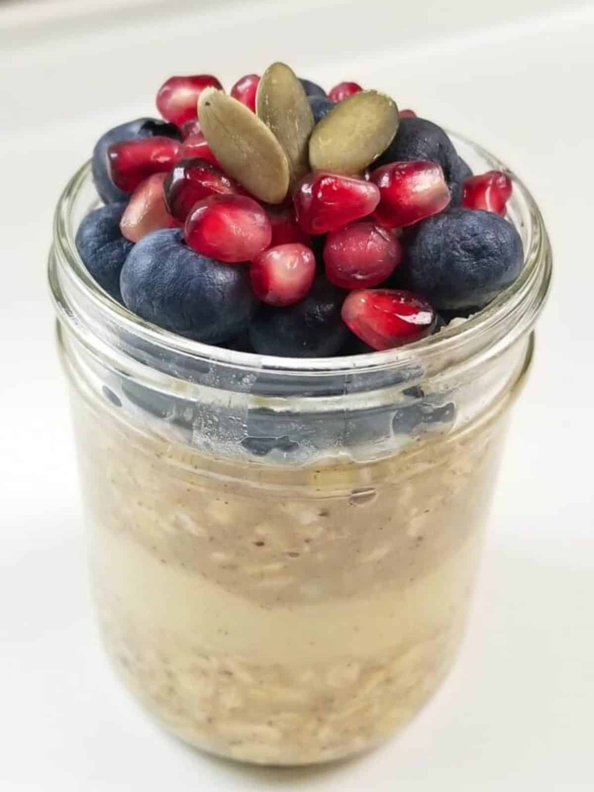 delicious jar of overnight oats featuring a mix of rolled oats, creamy filling, fruits, and nuts.