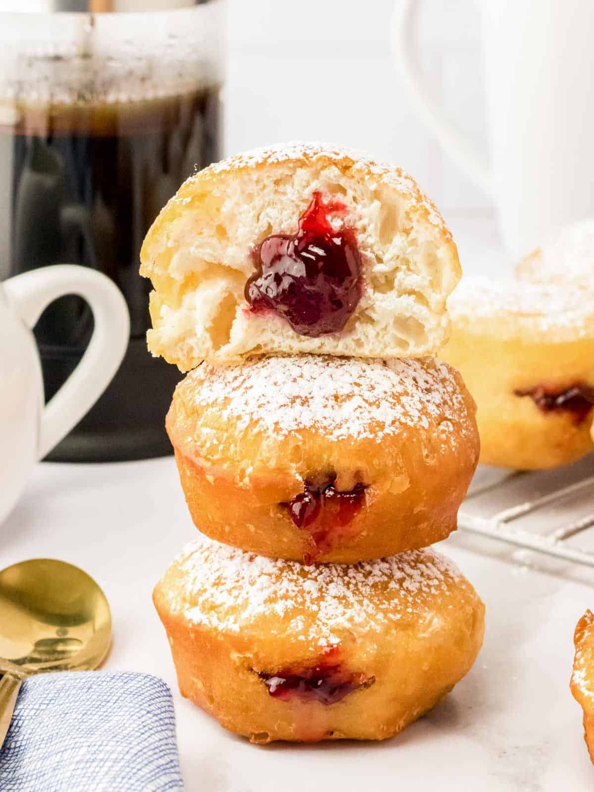 stack of delicious raspberry jelly donuts, dusted with powdered sugar.