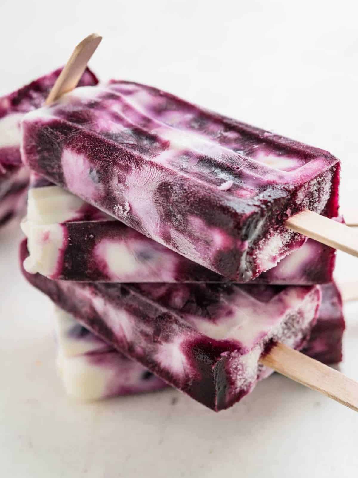 creamy blueberry swirl yogurt popsicles with loads of chewy whole blueberries and a hint of lemon.