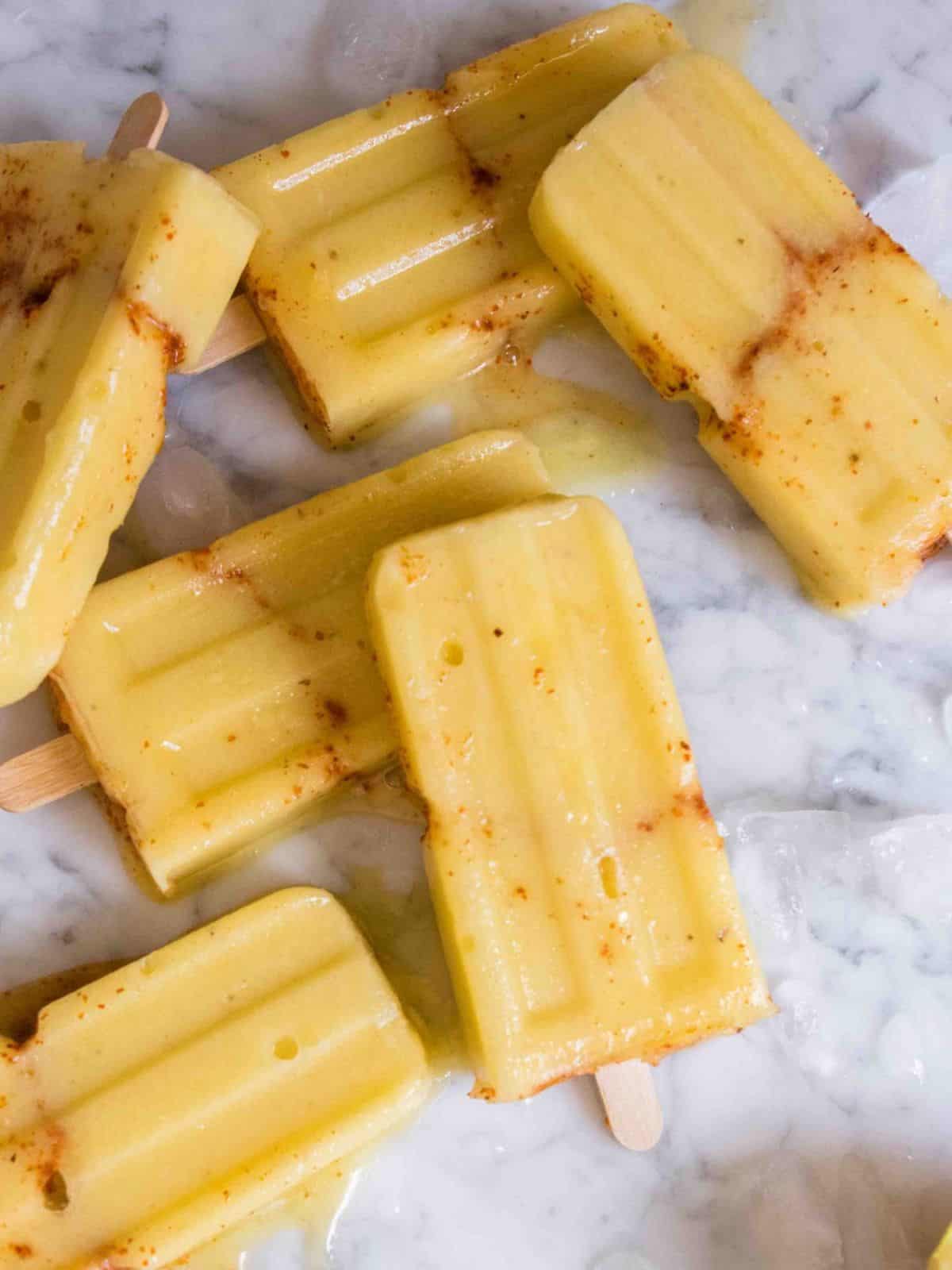 no sugar added tajin healthy pineapple popsicles made with fresh pineapple, bananas, and a sprinkle of tajin.