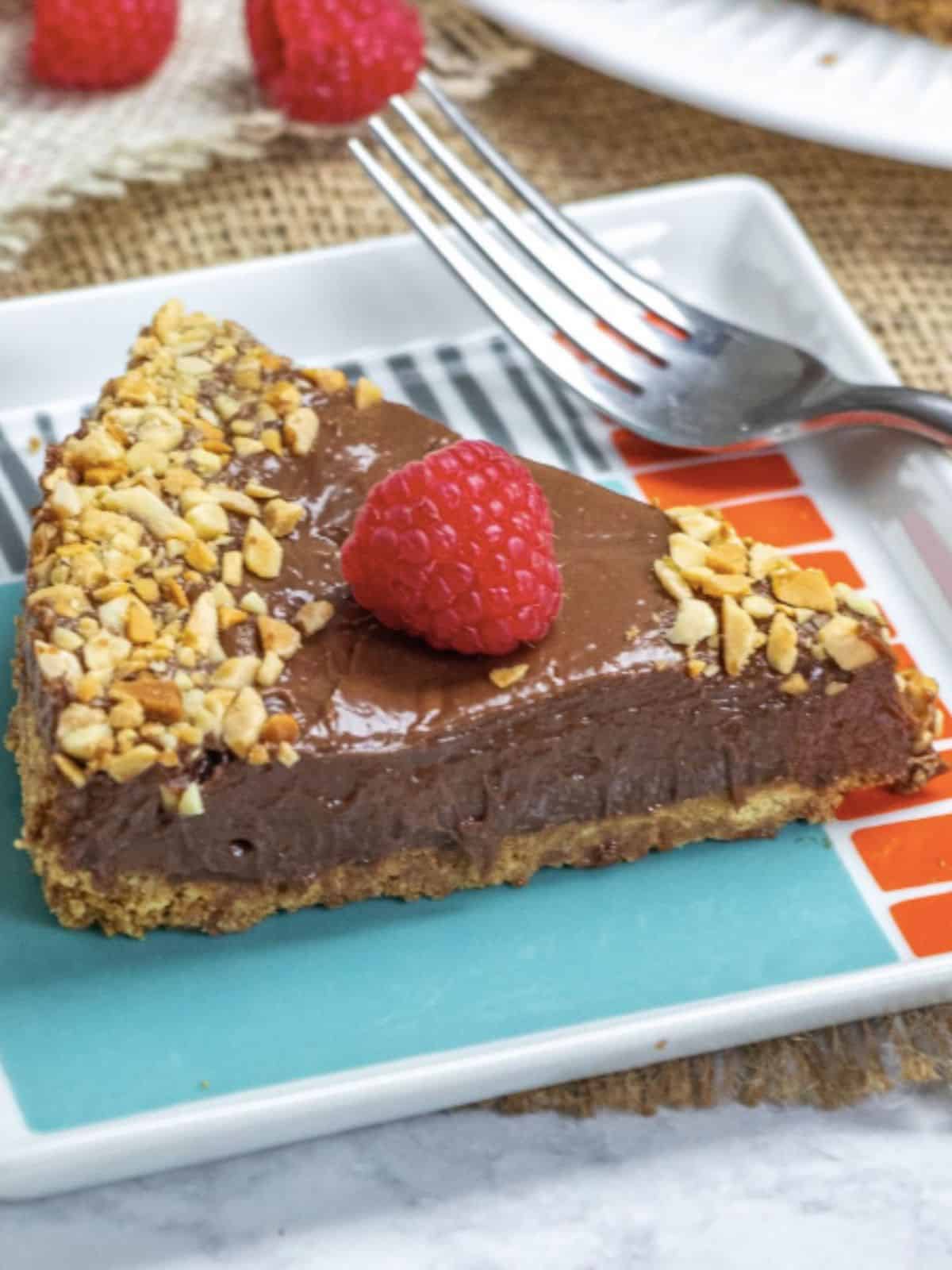 no-bake Ferrero Rocher cheesecake with a Nutella graham cracker bake and nuts on top.