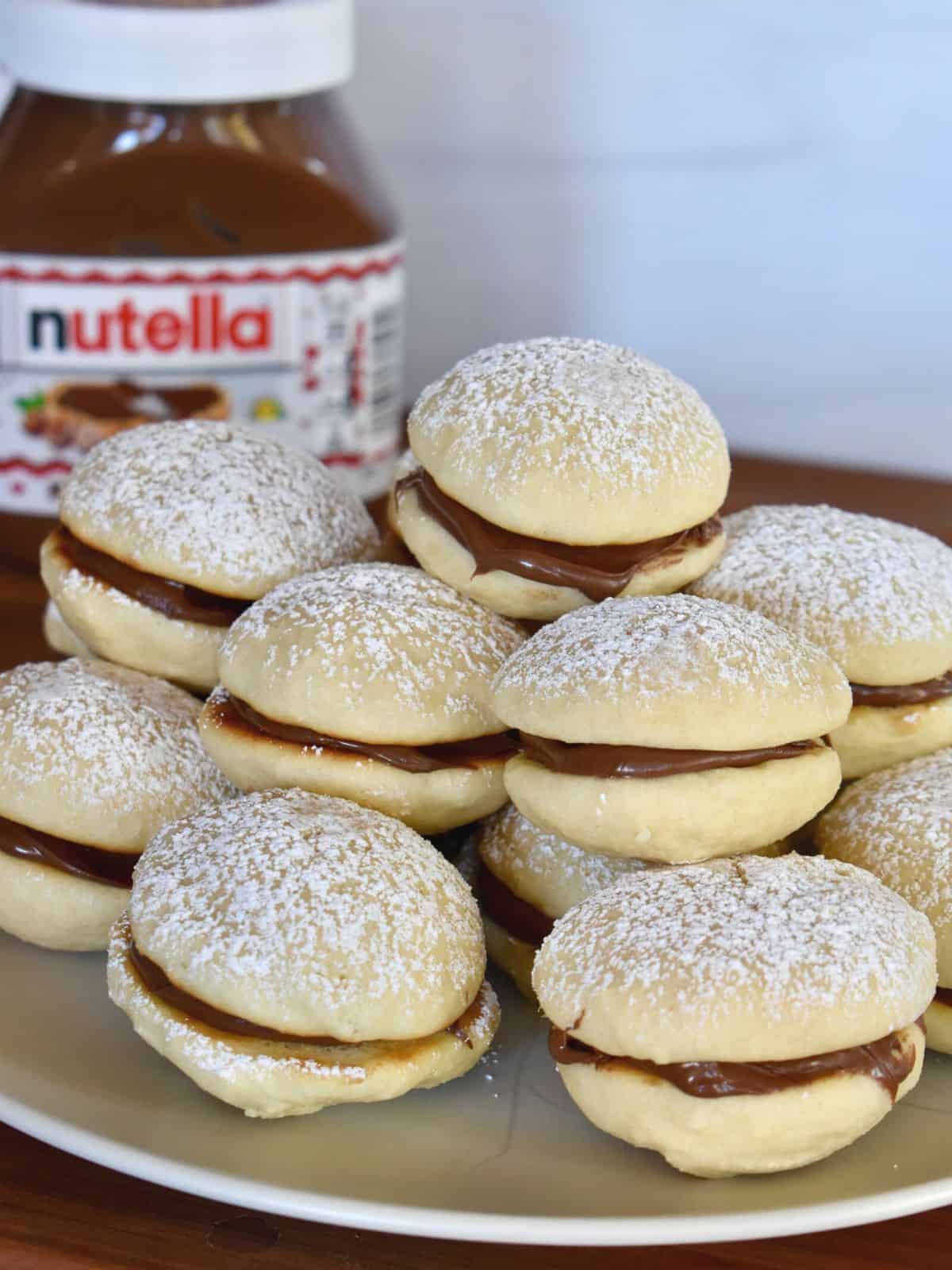 Nutella sandwich cookies made with soft ricotta cookies.