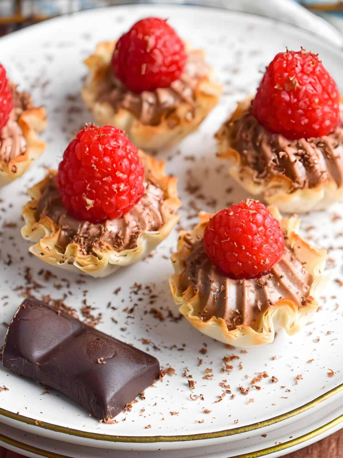 one-bite Nutella tartlets topped with fresh raspberries and grated dark chocolate.