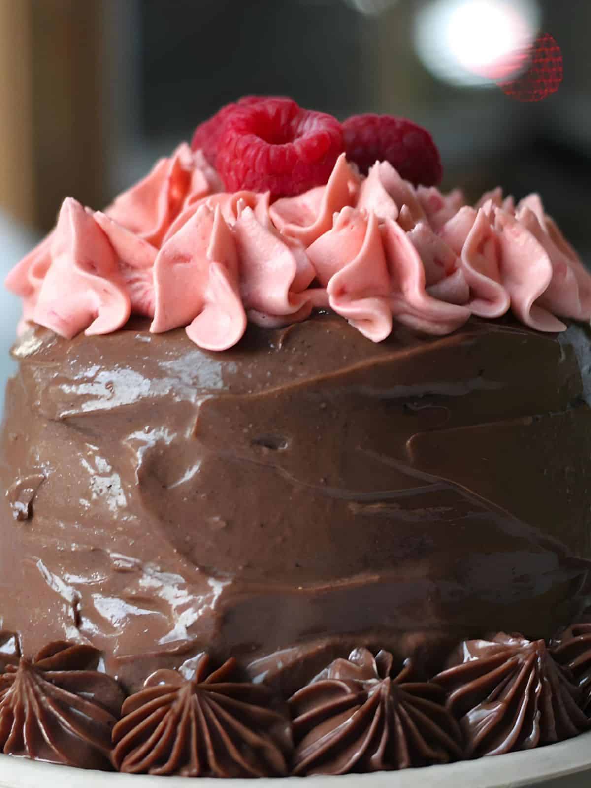 gluten-free and vegan raspberry Nutella cake topped with luscious raspberry Nutella frosting and fresh raspberries.