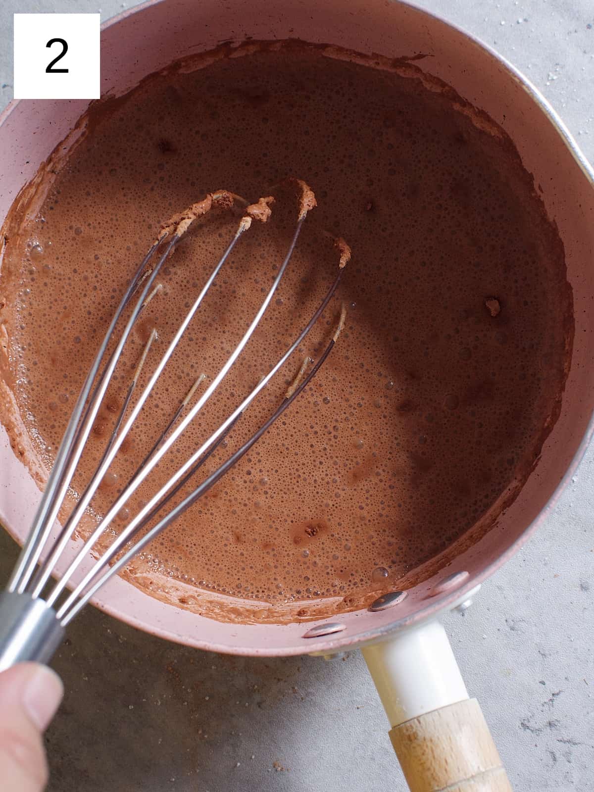 Whisking a dissolved cocoa powder in a sauce pan.