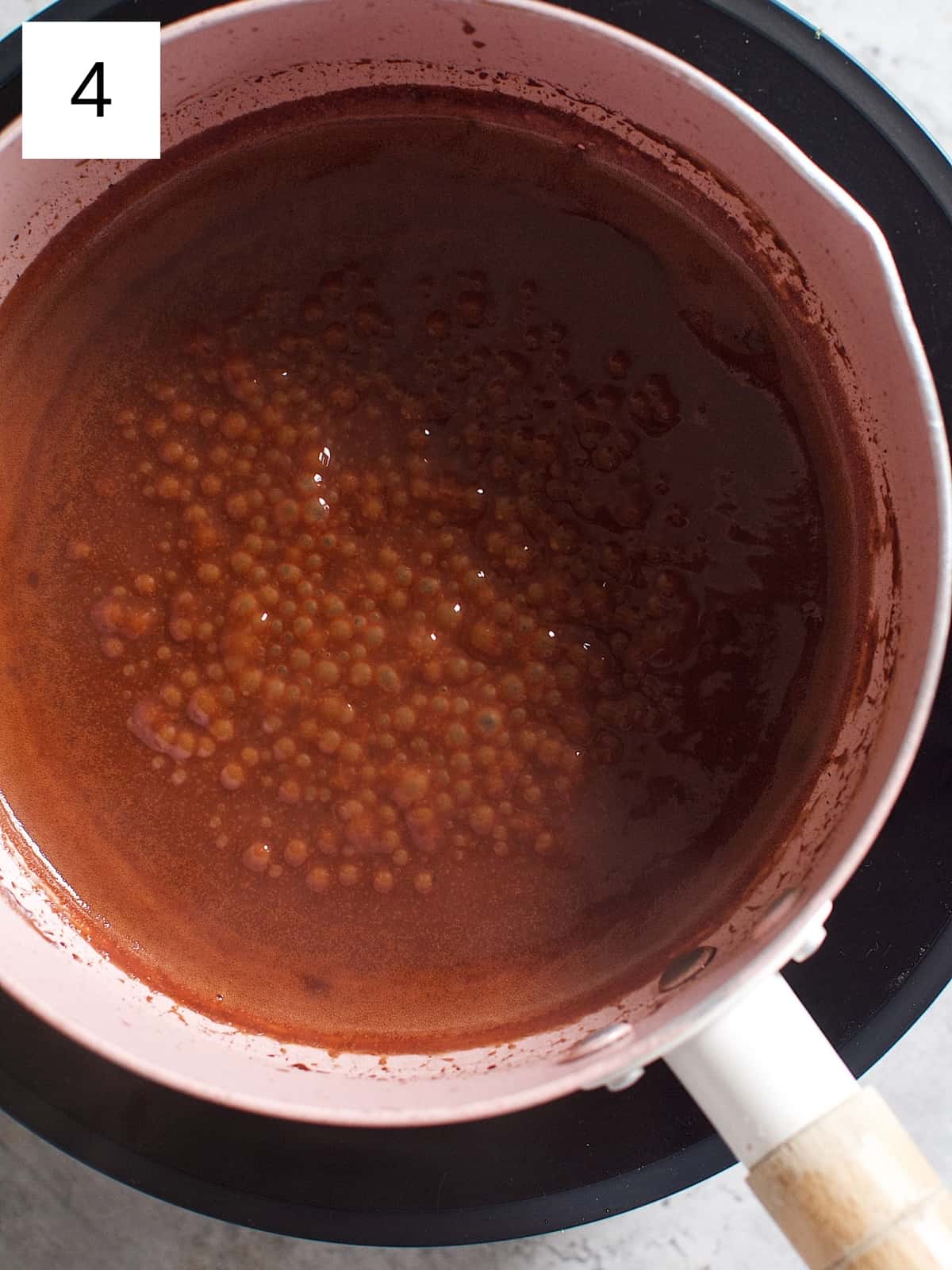 Cocoa mixture is being soft boiled in a heated sauce pan.