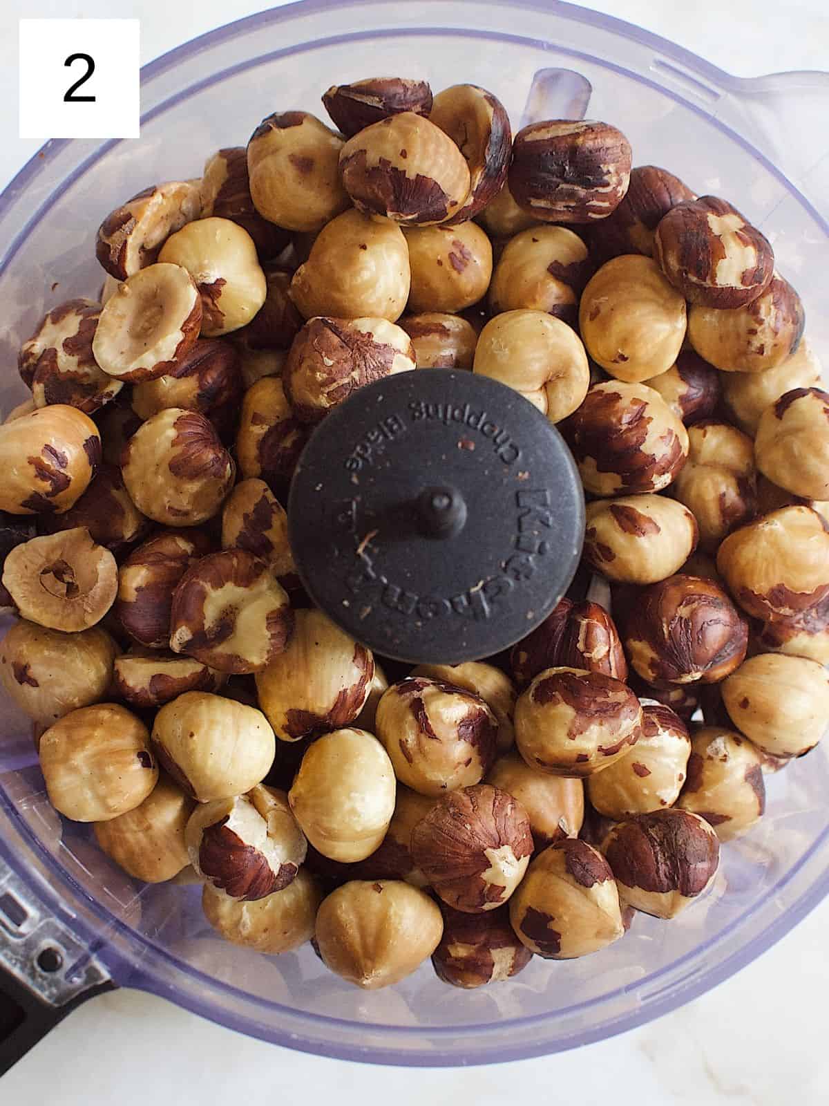 Toasted hazelnuts in a food processor.