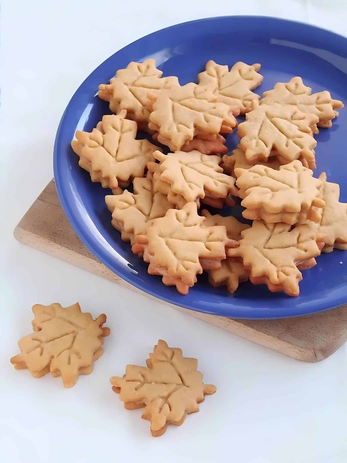 Maple leaf designed cookies on a blue plate.