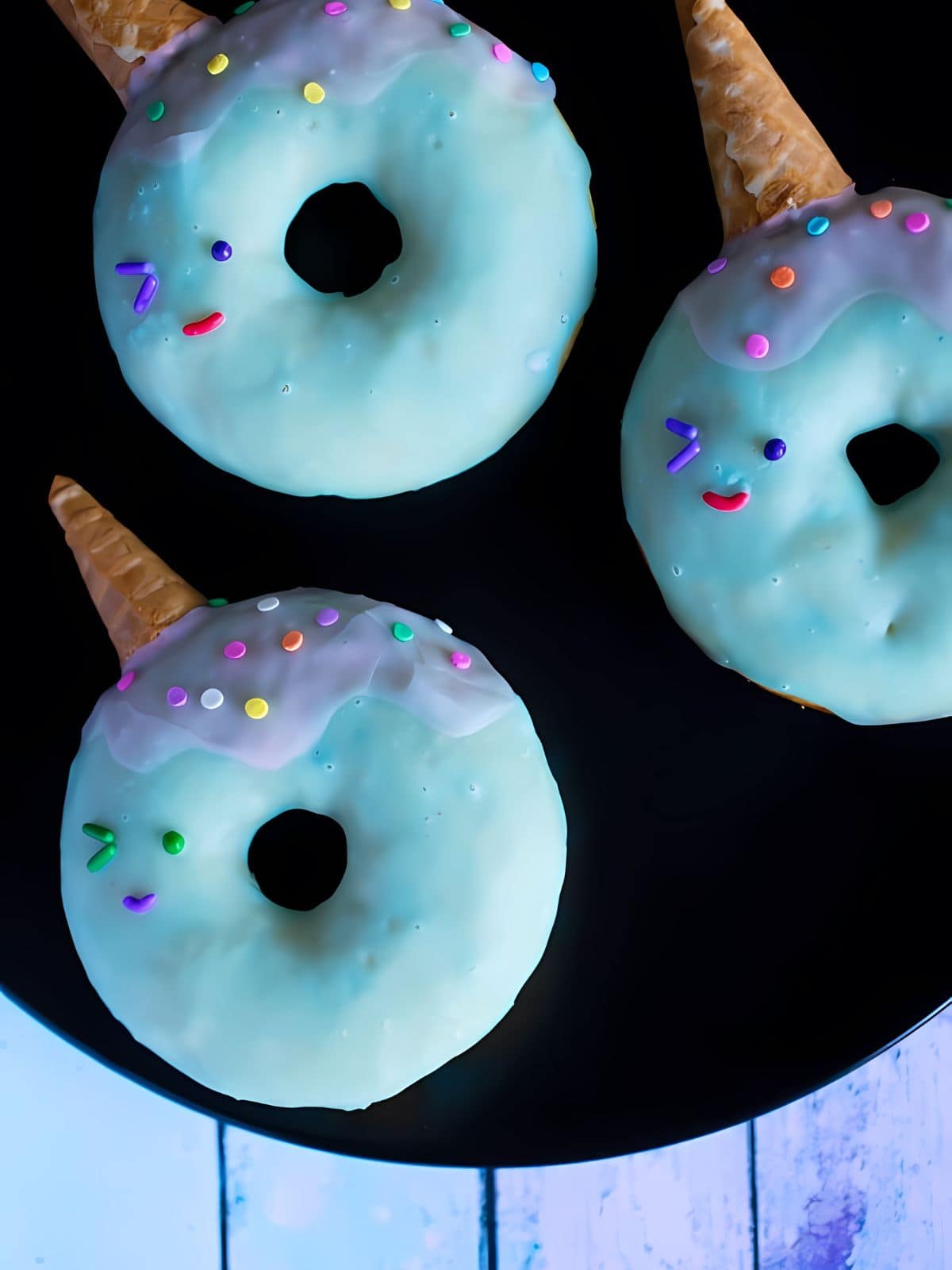 Narwhal glazed donuts with cone and sprinkles on top.