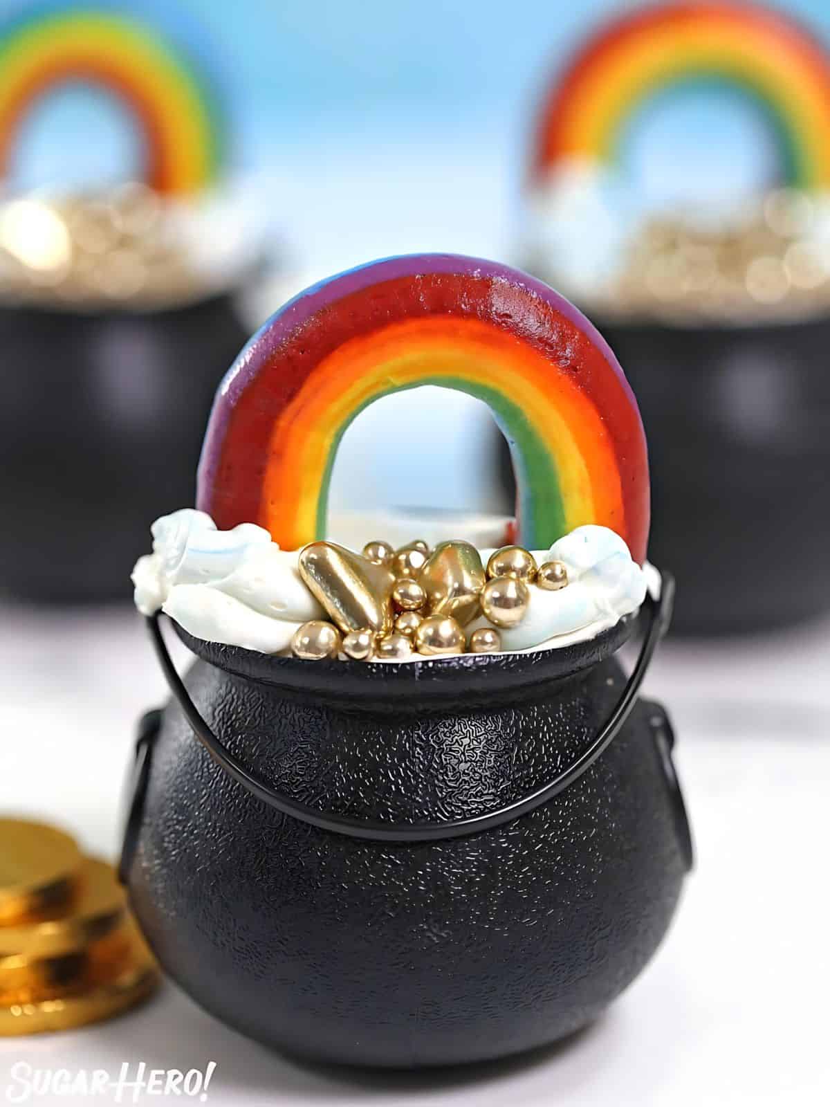 Pot of gold cupcakes on topped with frosting and rainbow candy.