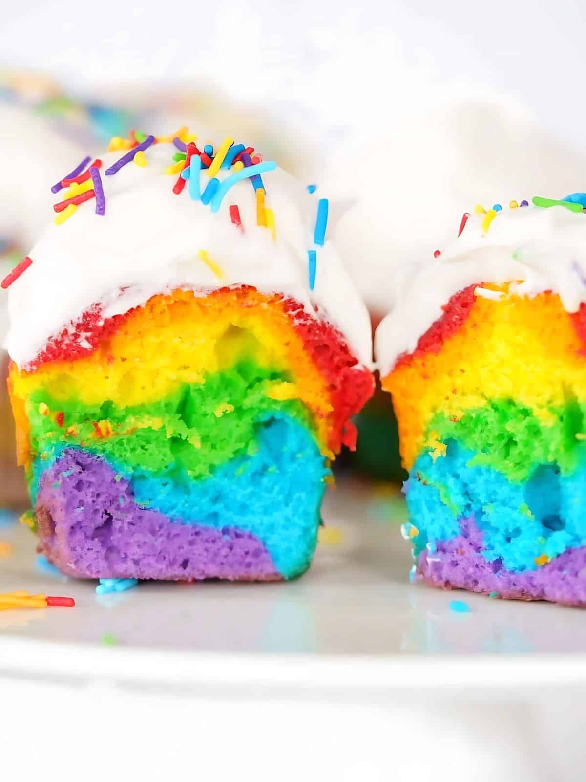Rainbow cupcakes topped with colorful sprinkles and frosting.
