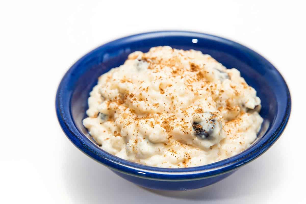 Tasty and sweet Arroz con Leche in a blue bowl sprinkled with cinnamon.