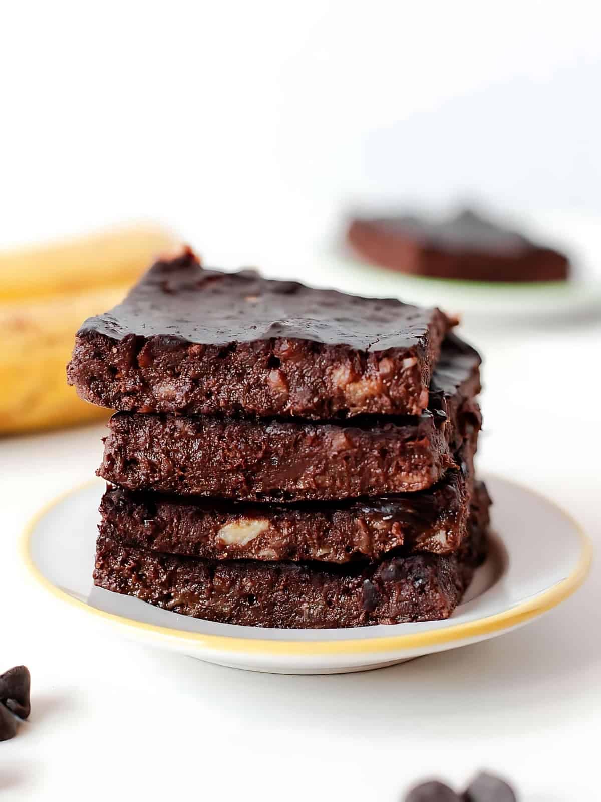 Stacked chocolate banana brownies on a small plate.
