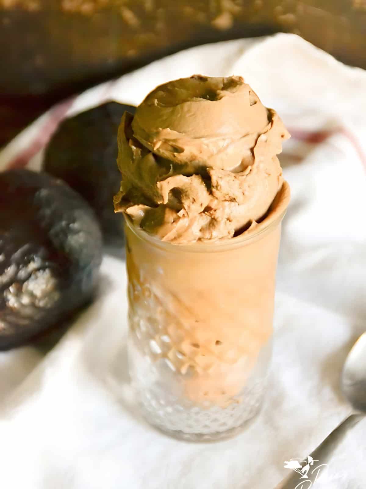 Scoops of chocolate avocado ice cream in a glass.
