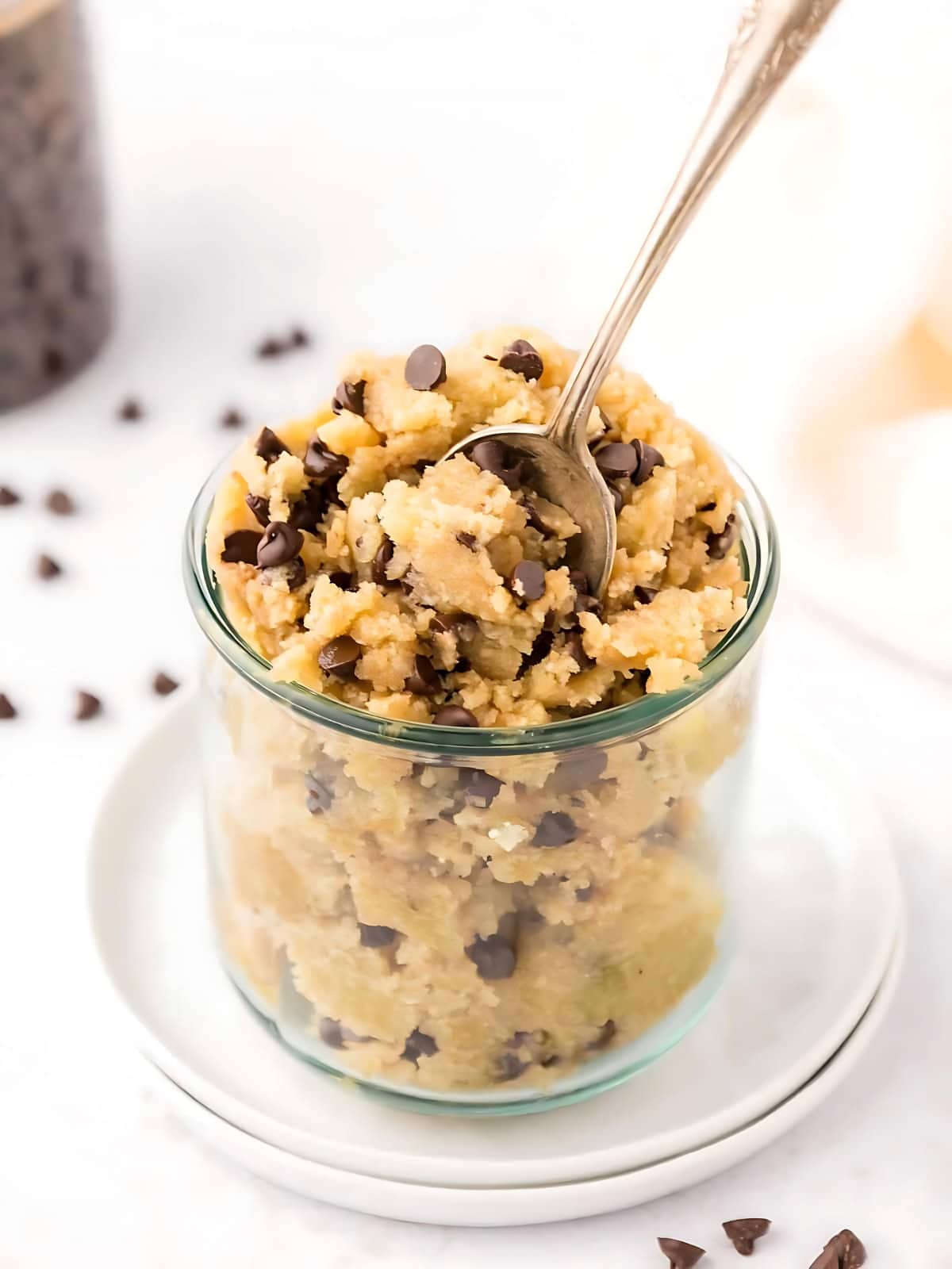 Edible cookie dough in a glass with chocolate chip toppings.
