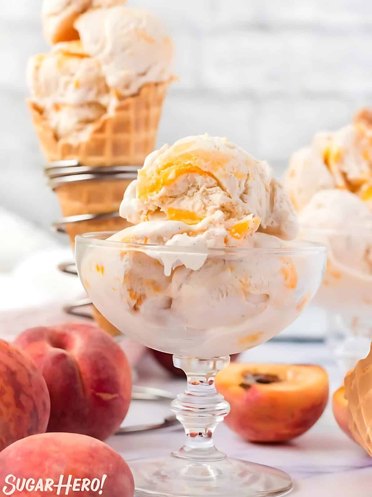 Peach ice cream in a glass cup with fresh slices of peaches.