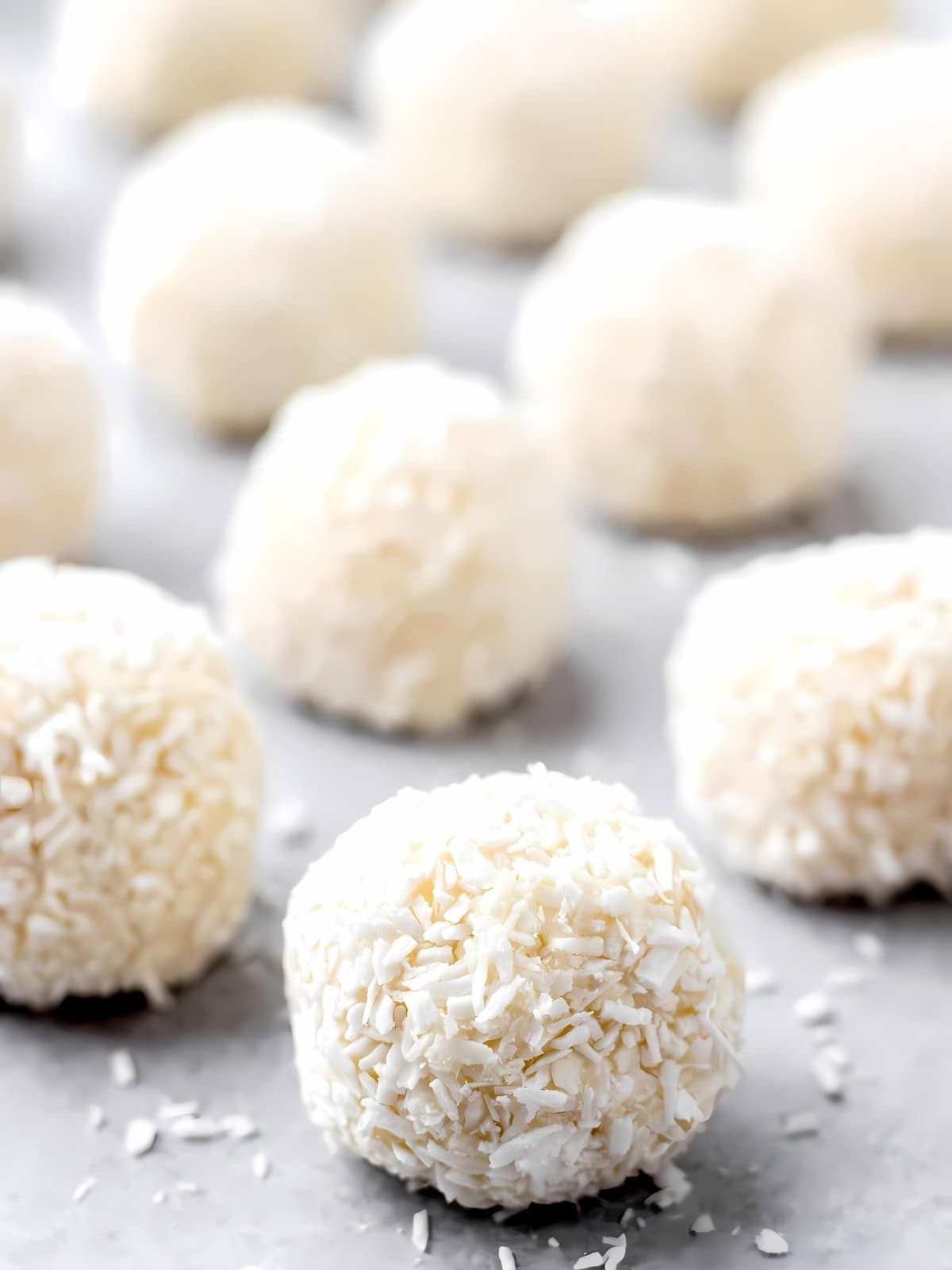 A bunch of white chocolate coconut truffles sprinkled with coconut shavings.