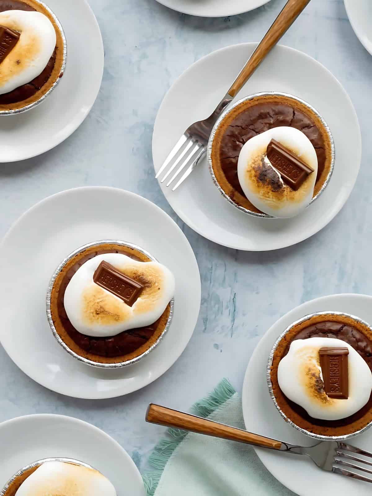 Mini Smores Pies on plates, topped with Hershey's chocolate bar.