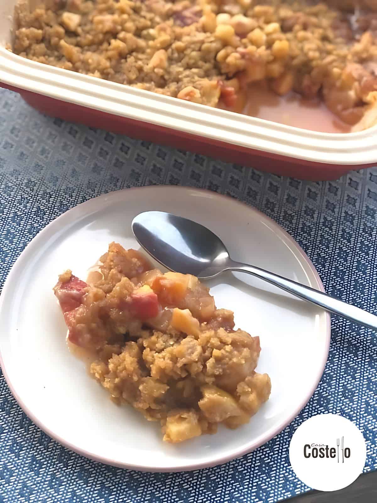 A serving of peach and marzipan crumble on a plate.