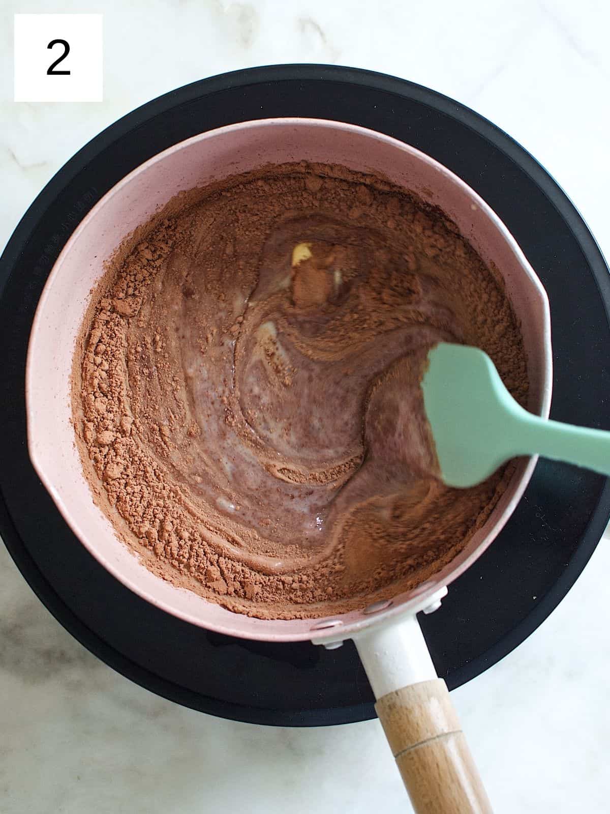 a mixture of butter, sweetened condensed milk, and cocoa powder in a saucepan.
